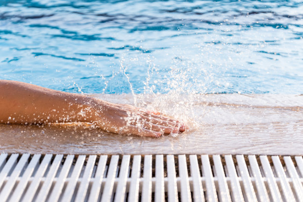 我的手碰到了池子里的瓦片，溅起了水。冻结的运动。在户外图片下载