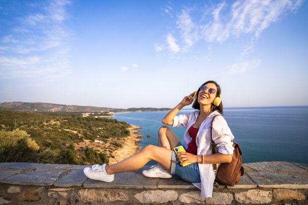 一个年轻的女人在海上听音乐图片下载