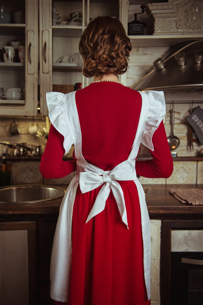 家庭主妇在厨房里拿着一块巧克力大理石蛋糕，50年代的复古风格图片下载