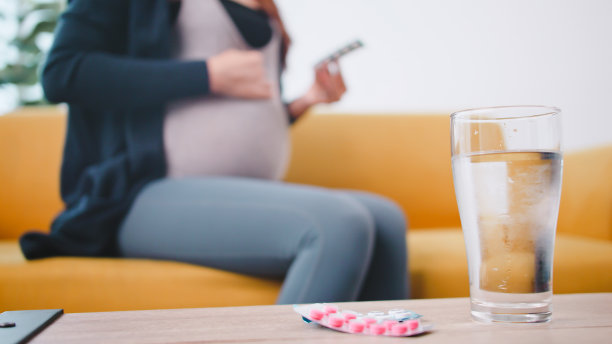 年轻孕妇在家吃药。图片下载