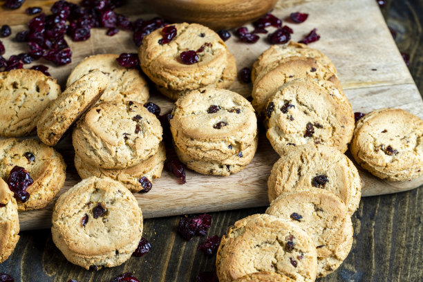 桌上有优质面粉制成的美味干曲奇饼和干红蔓越莓图片下载
