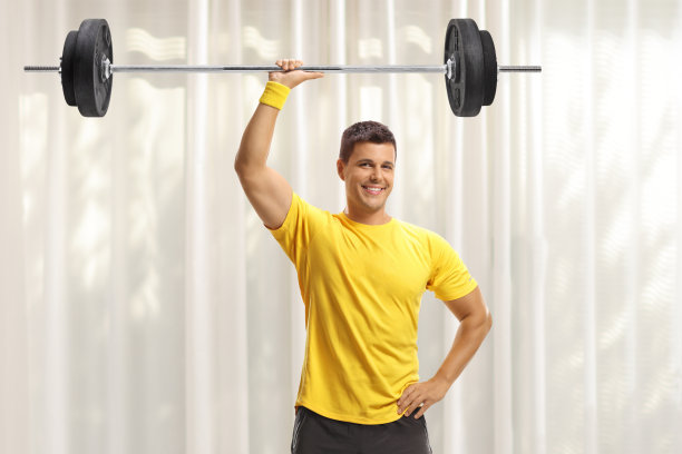 年轻的健美男子在家里举重图片下载