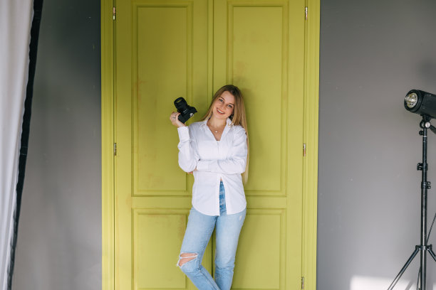 女摄影师手握相机微笑图片下载