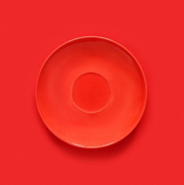 红色的桌子上有红色的盘子。单色极简形象在潮人的风格。图片下载