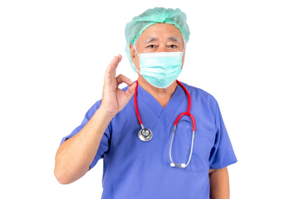 身穿制服的医生肖像，亚裔医生老人戴着白色背景的听诊器口罩。图片下载