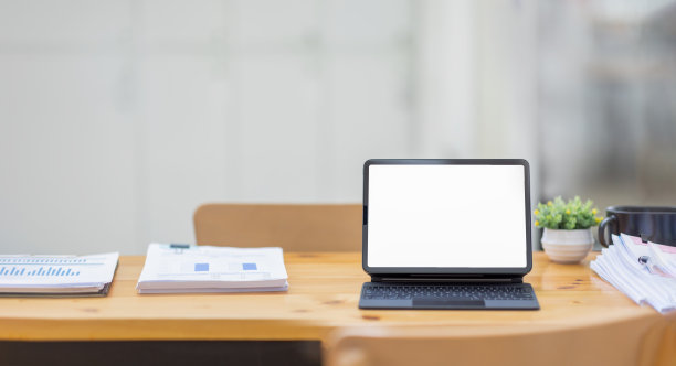 笔记本电脑屏幕，笔记本电脑，笔记本拷贝空间，工作时间后坐在一个大的开放办公空间的桌子上的眼镜图片下载