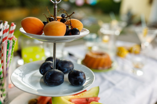 茶摊上摆放着新鲜的梅子、杏子和葡萄，为一场有趣的夏日游园会服务图片下载