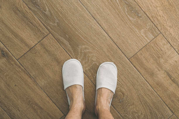 酒店房间内有男士脚和一次性白色拖鞋图片下载