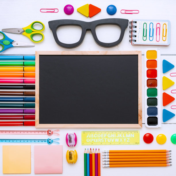 平铺文具粉笔板在一张白色背景的桌子上，打结。图片下载