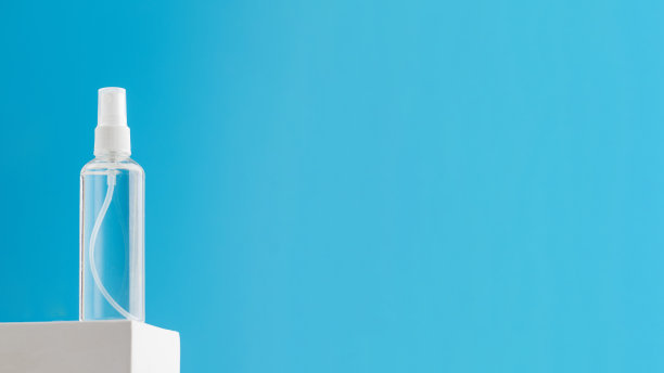 用胶束水和保湿乳液喷在蓝色背景的白色底座上。本空间图片下载