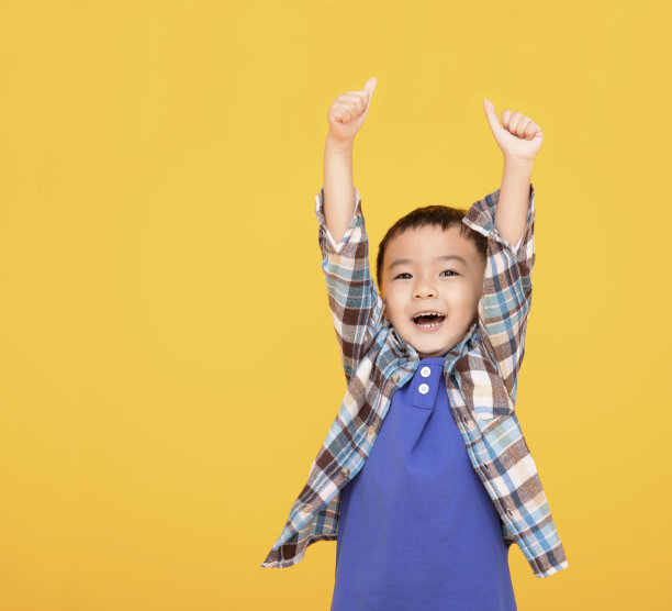 快乐的亚洲男孩在黄色背景前竖起大拇指图片下载