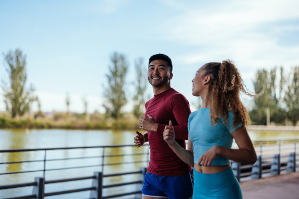 一对运动型情侣在河边跑步图片下载