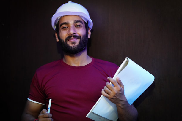 快乐的学生工程师戴着坚硬的白色帽子图片下载