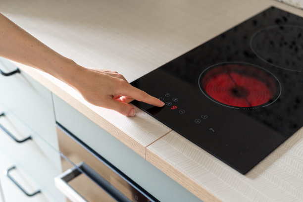 用手按下厨房电炉上的按钮图片下载