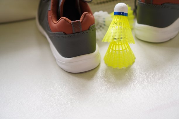 羽毛球:图片显示羽毛球拍，羽毛球和鞋训练，特写，室内运动，运动器具。图片下载