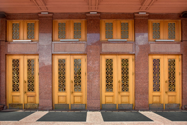 老建筑外立面为大理石入口木门、彩花玻璃窗，门槛橡胶脚垫，商务中心正门上方为装饰窗和彩灯。图片下载