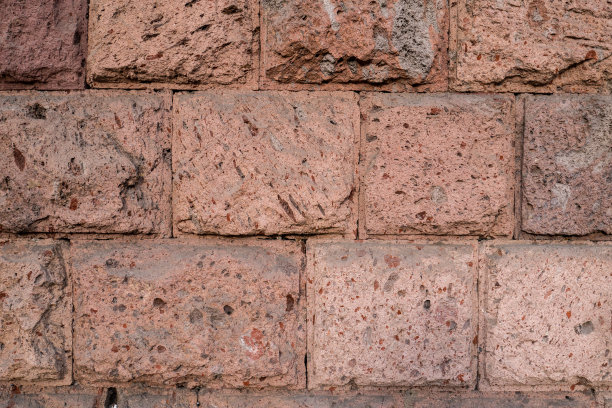 墙的纹理与粗糙的切割采石场面砖石灰石在红色和棕色图片下载