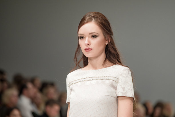 在时装周上工作的时装模特的女性肖像。后台摄影，幕后的新服装收藏。女孩穿着时尚设计师设计的服装走上讲台图片下载