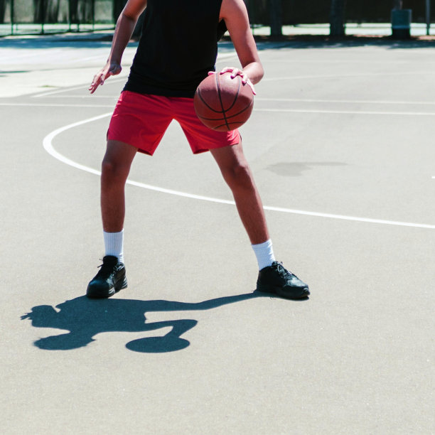 一名面目全非的白人男子在城市街道的篮球场上打篮球图片下载