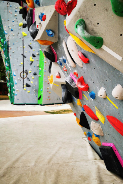 人工攀岩抱石墙，展示各种彩色握把。图片下载