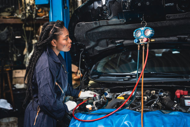 女机械师正在用歧管仪表测量空调。图片下载
