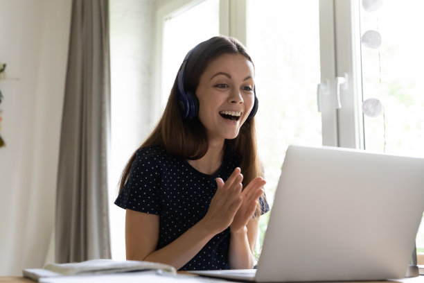 兴高采烈兴奋的女学生戴着耳机，欣喜于好消息图片下载