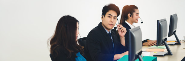 年轻的商业呼叫中心亚洲男子使用耳机和电脑。图片下载