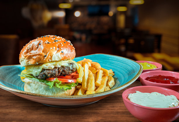 牛肉汉堡配薯条、沙拉和奶油。图片下载