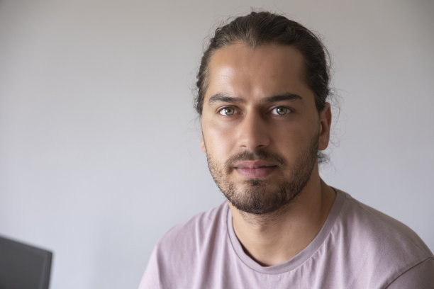 年轻英俊的建筑师，一头长发，坐在办公室里图片下载