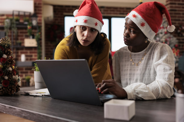 戴着圣诞帽的多民族女性团队在工作图片下载