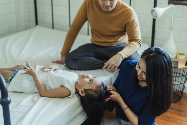 父母在家幸福地帮女儿穿衣服图片下载