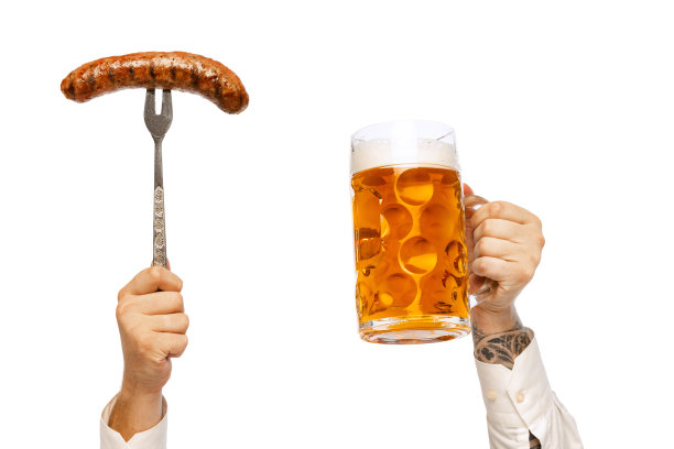 男性的手与烤香肠上的叉子和杯子与泡沫拉格啤酒孤立在白色的工作室背景。德国和巴伐利亚的节日图片下载
