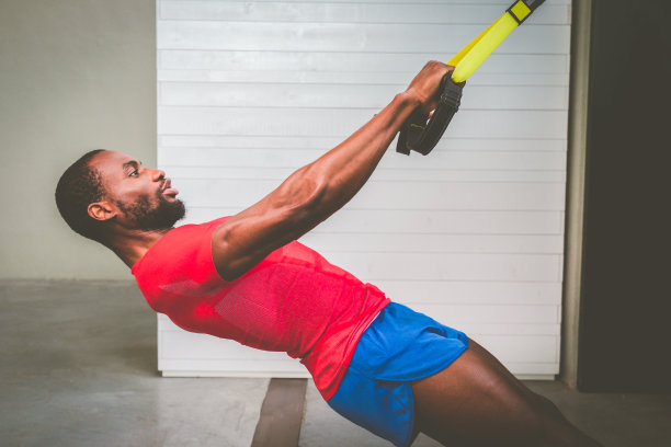 年轻的黑人私人教练训练武器与trx健身带在健身房-迷人的非洲裔美国人做交叉健身俯卧撑与trx健身带在健身房工作室图片下载