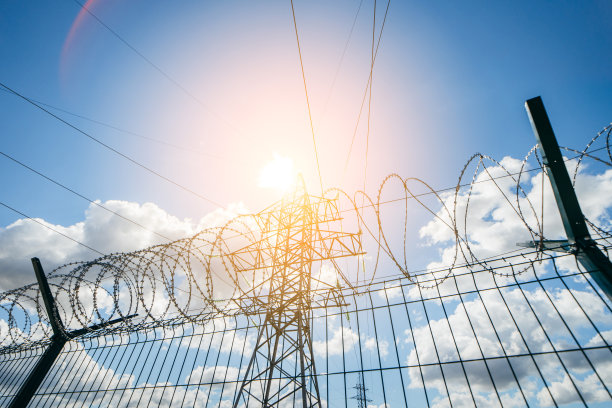 高压电线。现代电站围栏后的高压输电塔。图片下载