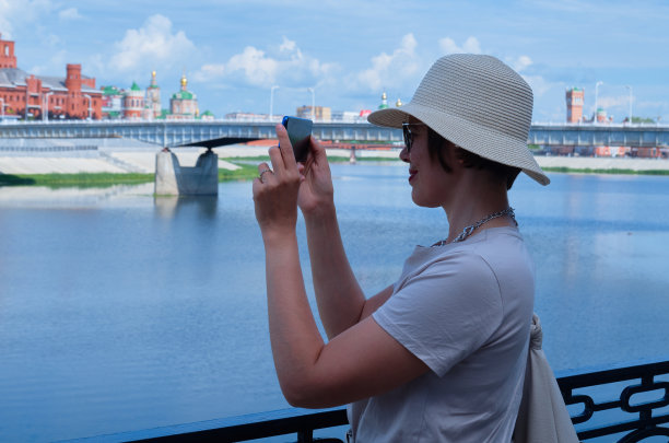 一名戴着草帽的女游客的蓝色色调摄影使城市街道上的移动照片图片下载