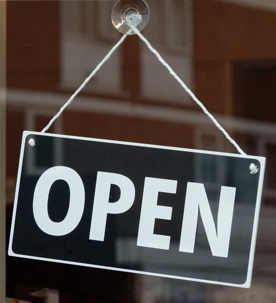咖啡馆的窗户上挂着一个开着的牌子。图片下载