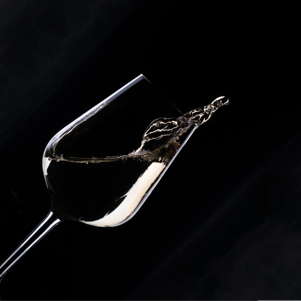 白葡萄酒飞溅在玻璃孤立在黑色背景图片下载