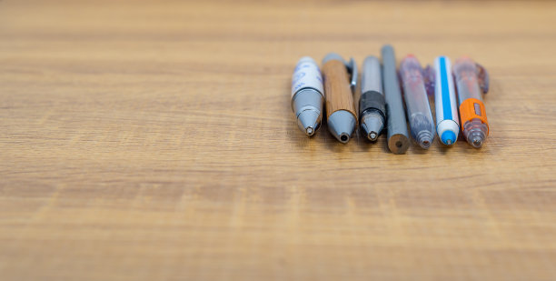 一组不同的笔和铅笔放在木桌上，复印空间，学校和设备的概念，软焦点，商业的不同方式的概念图片下载