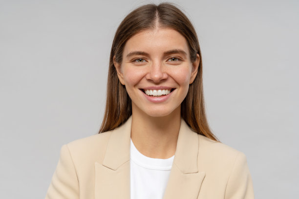 头像微笑的女教师看着相机在灰色的背景图片下载