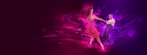 兴奋的男女专业舞者在黑暗背景下跳着林迪舞图片下载