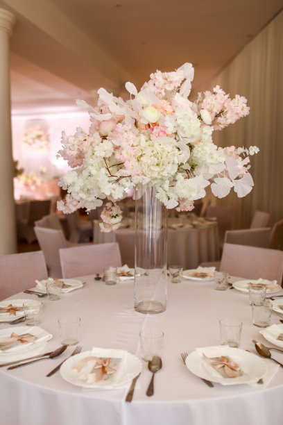 喜庆的婚礼装饰。美丽新鲜的白色和粉红色的花在玻璃花瓶在婚礼当天的餐桌上。高质量的照片图片下载