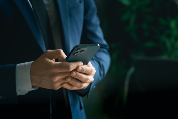 西装革履的商人，手里拿着手机。男人输入信息，使用社交网络。检查消息。商务会议。现代办公室。总经理、首席执行官。打电话来的合作伙伴。计划工作时间图片下载