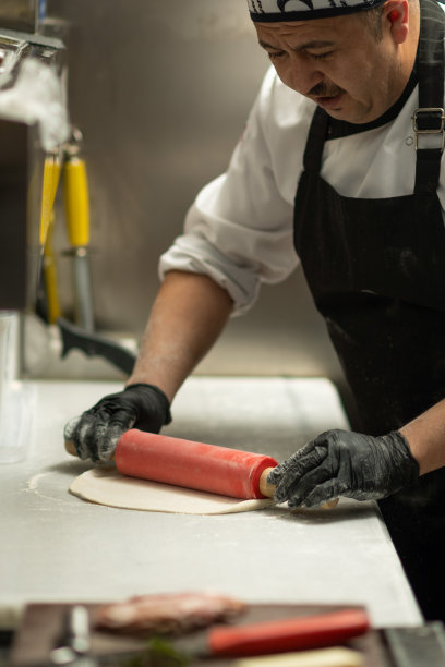 男厨师在厨房准备披萨图片下载