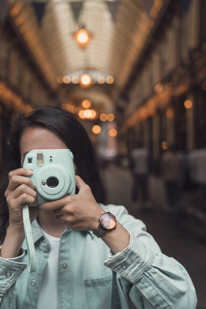 年轻女子拍摄照片与宝丽来相机图片下载