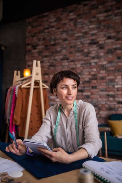 微笑的裁缝肖像附近的缝纫机图片下载