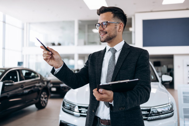 汽车经销商站在陈列室和摆姿势图片下载