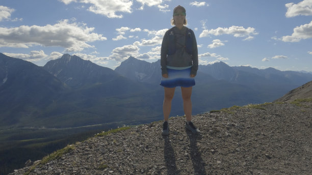 女子越野跑选手在山脊上停顿图片下载