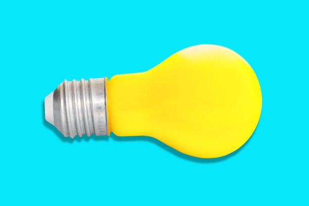 黄色灯泡孤立在蓝色背景图片下载