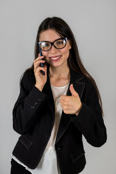 年轻的女学生在商业服装微笑广泛的照片孤立的背景。图片下载