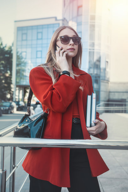 女商人在工作间隙站在市中心的大街上用手机图片下载